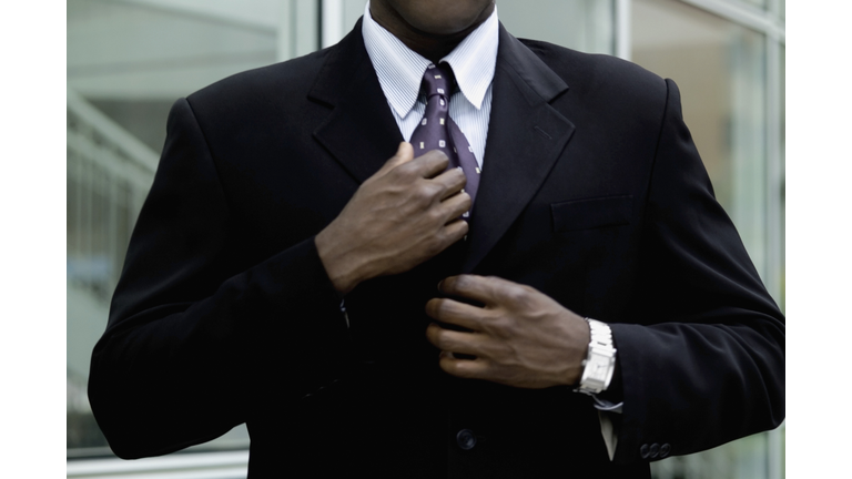 Man straightening tie, close-up