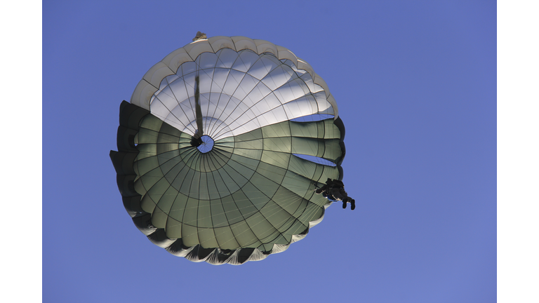 Low Angle View Of Person In Parachuting Against Clear Blue Sky