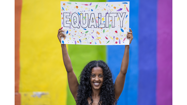 African American woman holding up 'Equality' poster