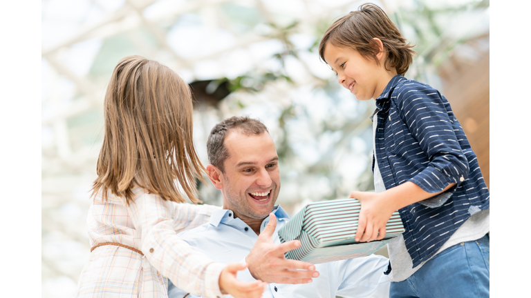 Kids surprising their father with a gift for Father's Day