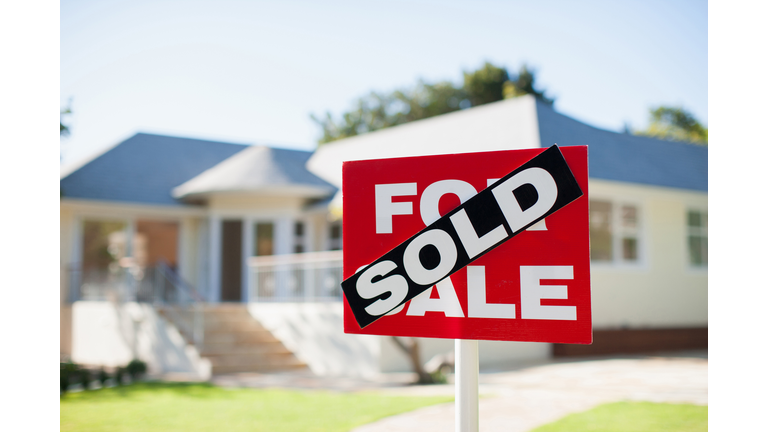 For sale sign in yard of house