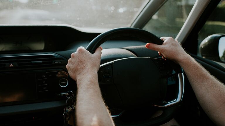 Man grips steering wheel with two hands