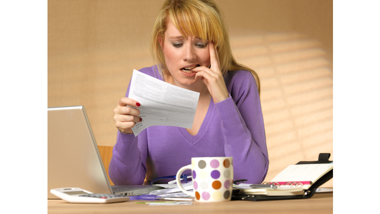 Teenager showing anxiety holding bill