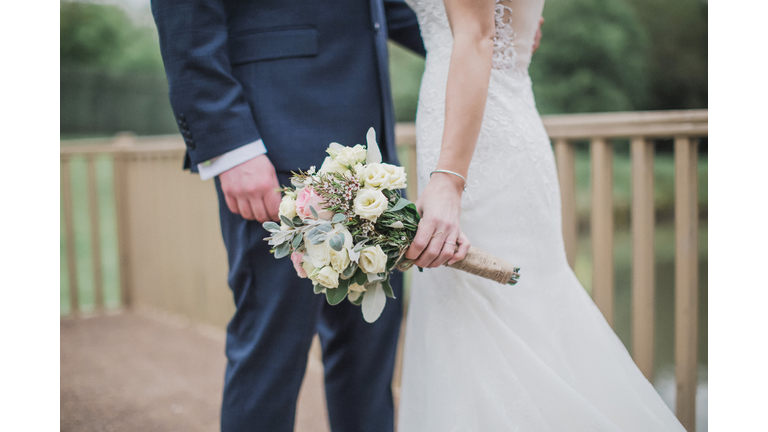 Midsection Of Newlywed Couple Standing Outdoors