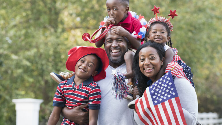 Portrait of Black family celebrating 4th of July in park