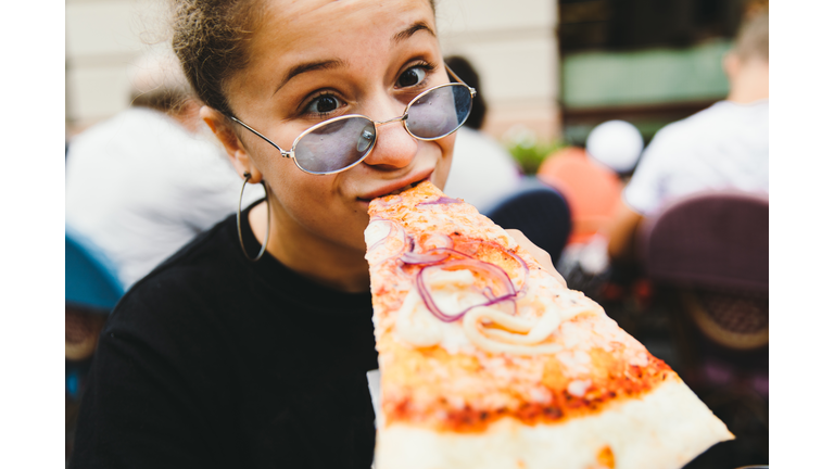 Young woman likes her pizza so much!