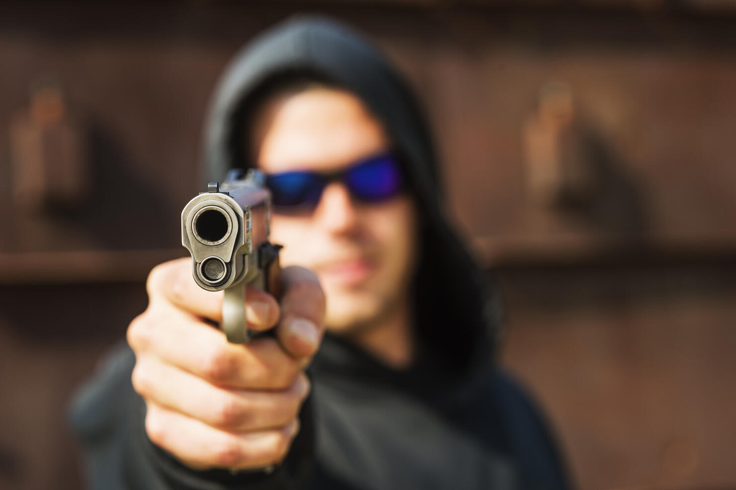 Man with handgun pointing towards camera