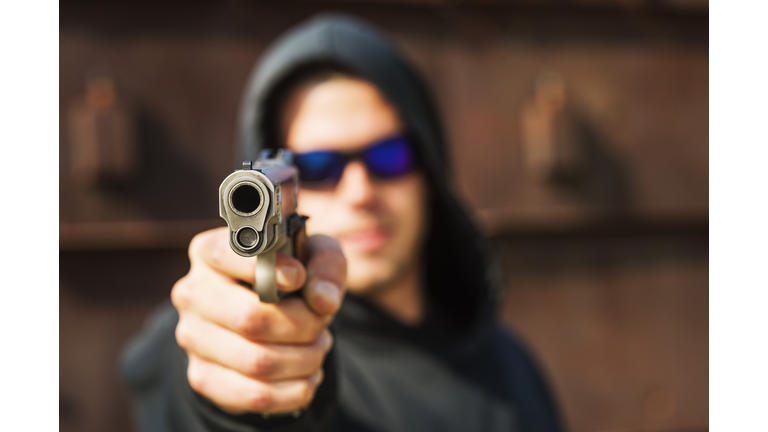 Man with handgun pointing towards camera