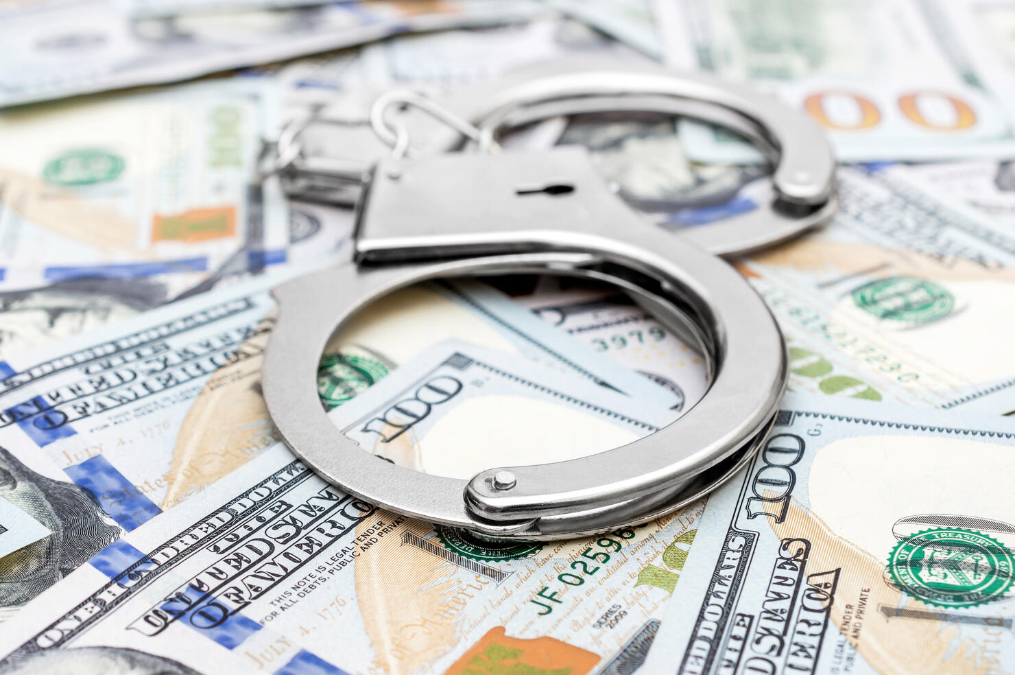 Handcuffs on the background of dollar bills.