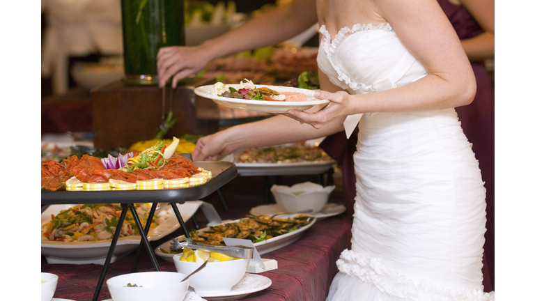 Bride getting food from buffet. 