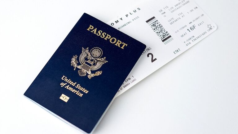 High Angle View Of Passport With Ticket Over White Background