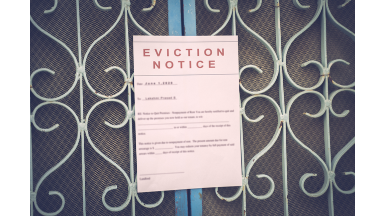 Foreclosed or eviciton notice on a main door with blurred details of a house with vintage filter.