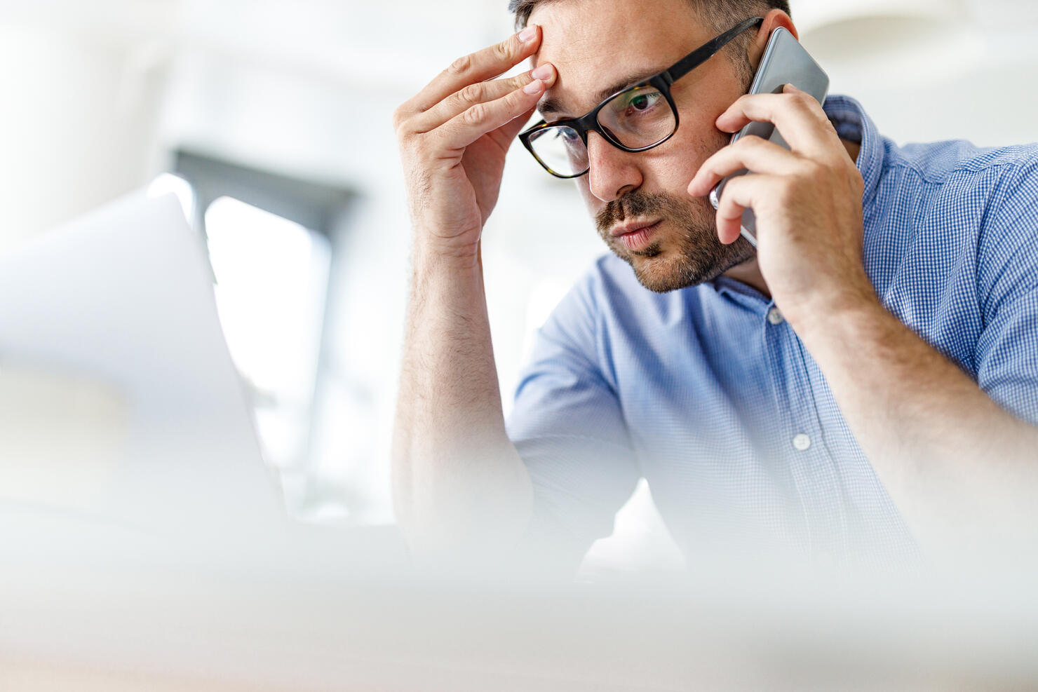 Worried businessman having problems while working on wireless technology at home.