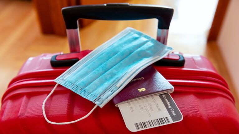 Face protection mask over passport and boarding ticket