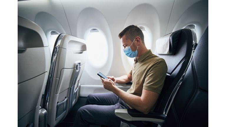 Man wearing face mask inside airplane
