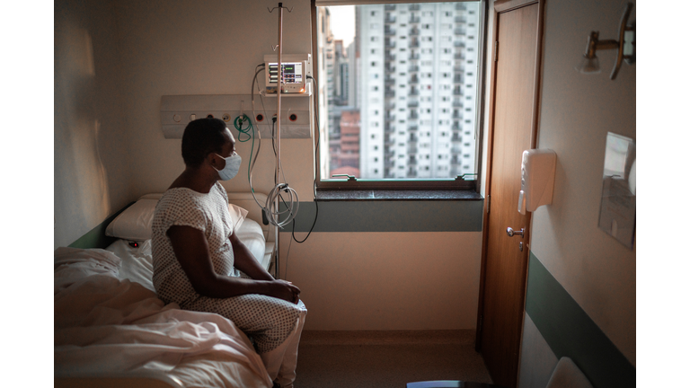 Senior patient using mask looking through window at hospital