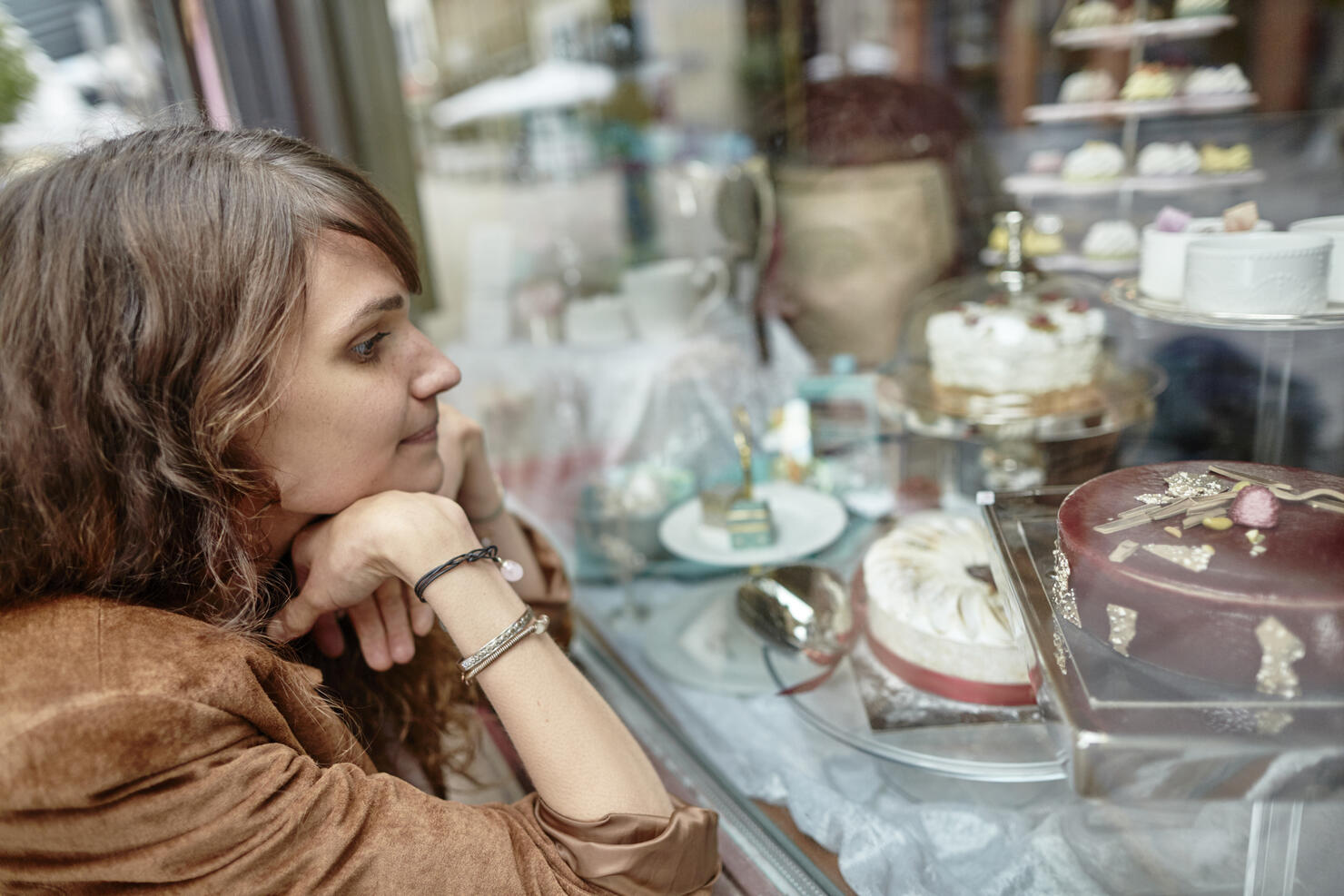 Young woman looking in shop window of a confectioner