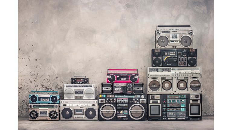 Retro old school design ghetto blaster boombox stereo radio cassette tape recorders tower from circa 1980s front aged concrete wall background. Vintage style filtered photo