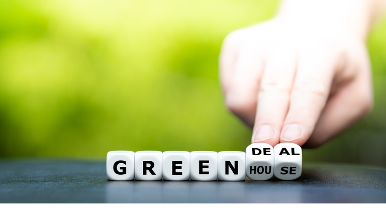 Hand turns dice and changes the expression "greenhouse" to "green deal".