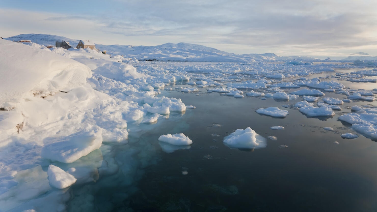 Winter landscape with ice sheets floating on the ocean surface.