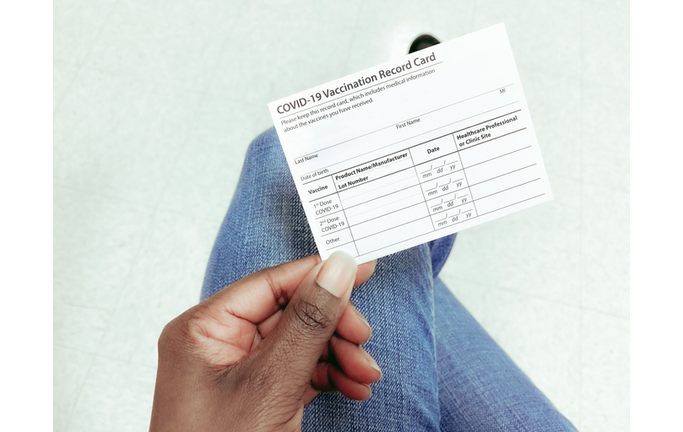 Woman Holds COVID-19 Vaccination Record Card