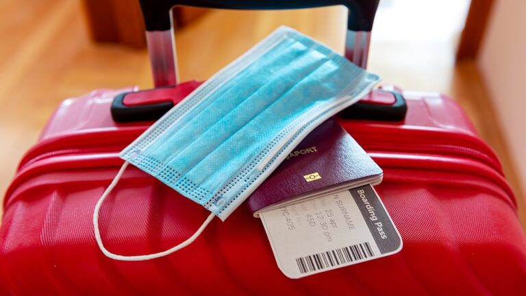 Face protection mask over passport and boarding ticket