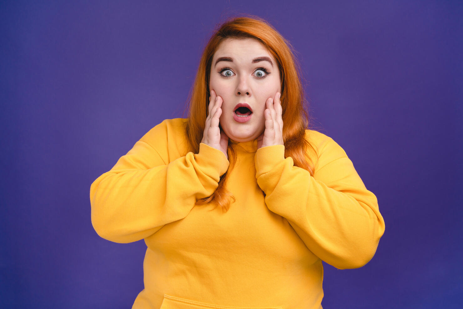 Shocked plump woman in casual outfit isolated in blue background