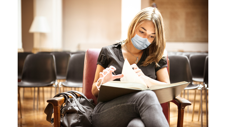 student with face mask in the library