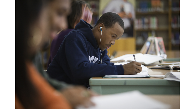 Teenage boy studying in school library