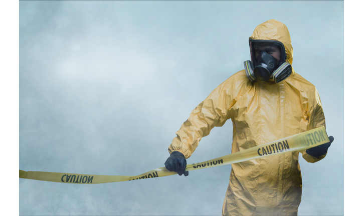 Worker in protective suit with cordon tape