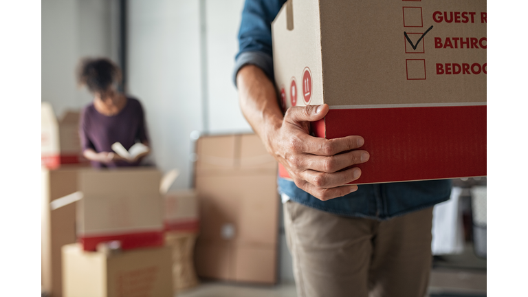 Hands holding cardboard box during relocation