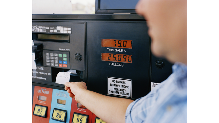 Man getting receipt from gas pump