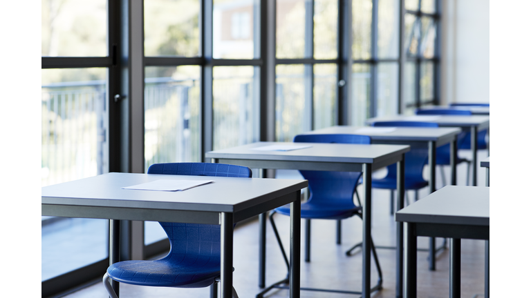 Papers on desks by window in classroom