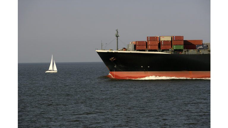 Container vessel and sailing boat at river Weser
