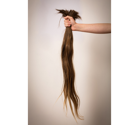 Out Stretched Arm Holding Long Cut Off Hair