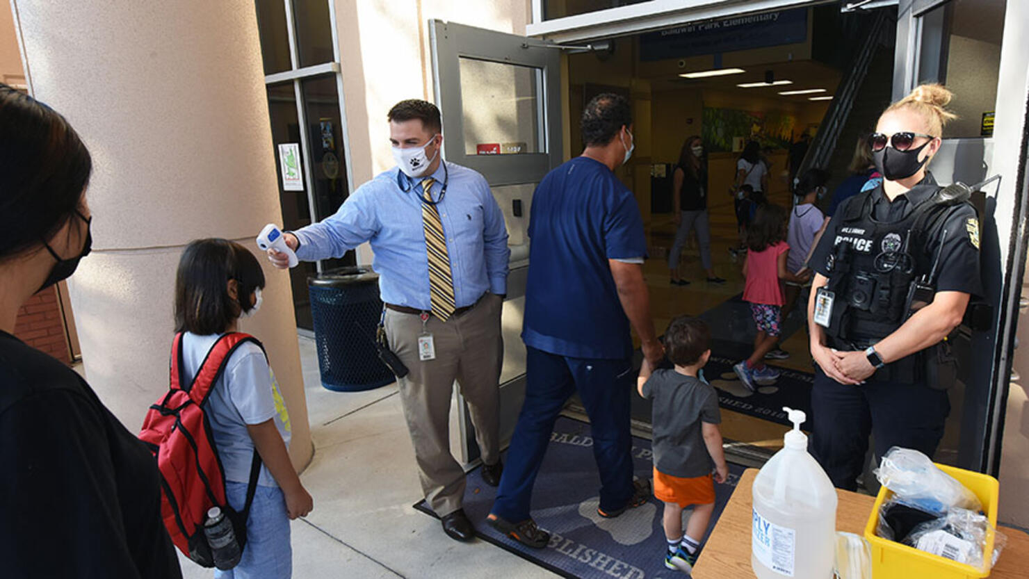 Principal Nathan Hay performs temperature checks on students