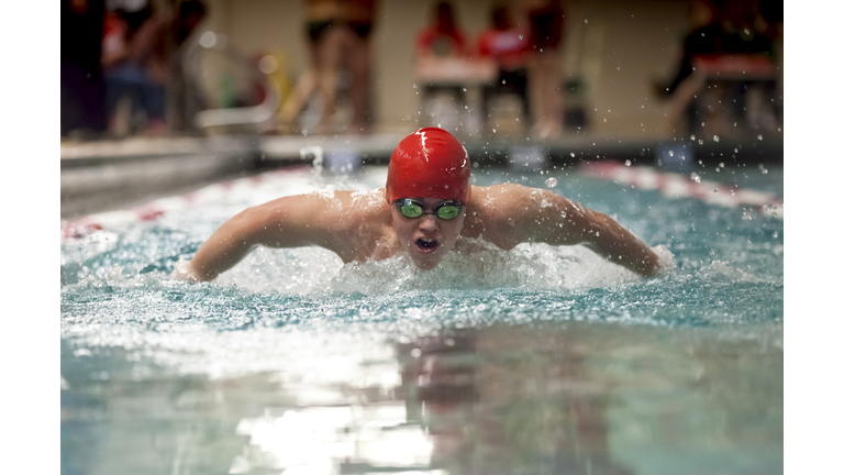 Young boy swimming butterfly stroke for school sports