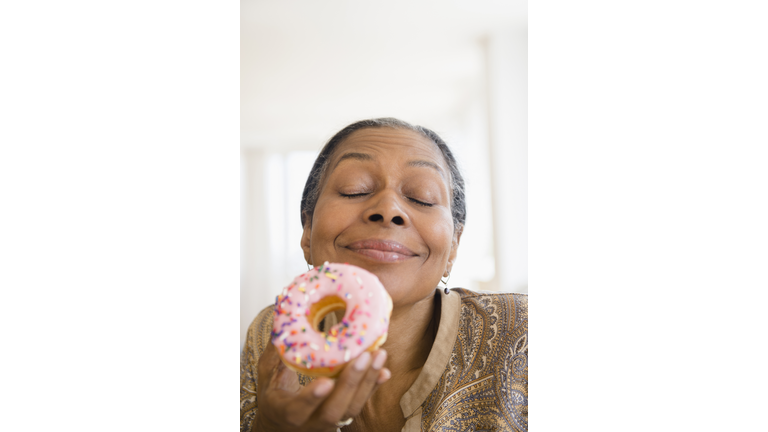 Mixed race woman eating donut