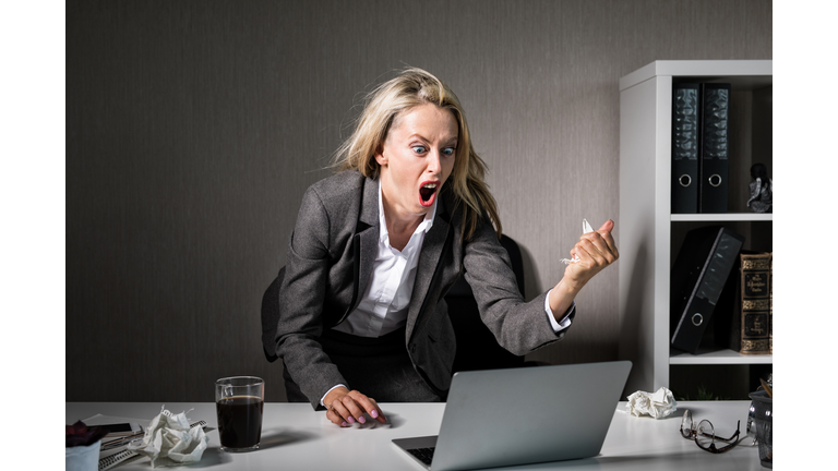 Woman angry at her laptop computer at work