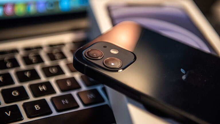 In this photo illustration, an iPhone 12 smartphone and its