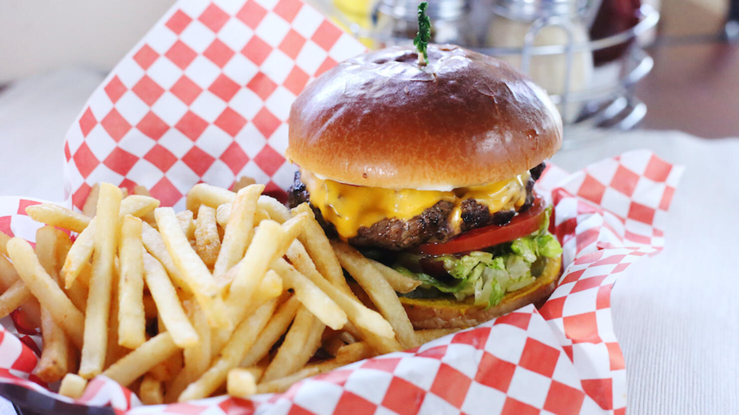 High angle view of burger with French fries served on table in restaurant