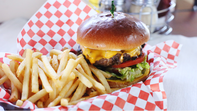 High angle view of burger with French fries served on table in restaurant