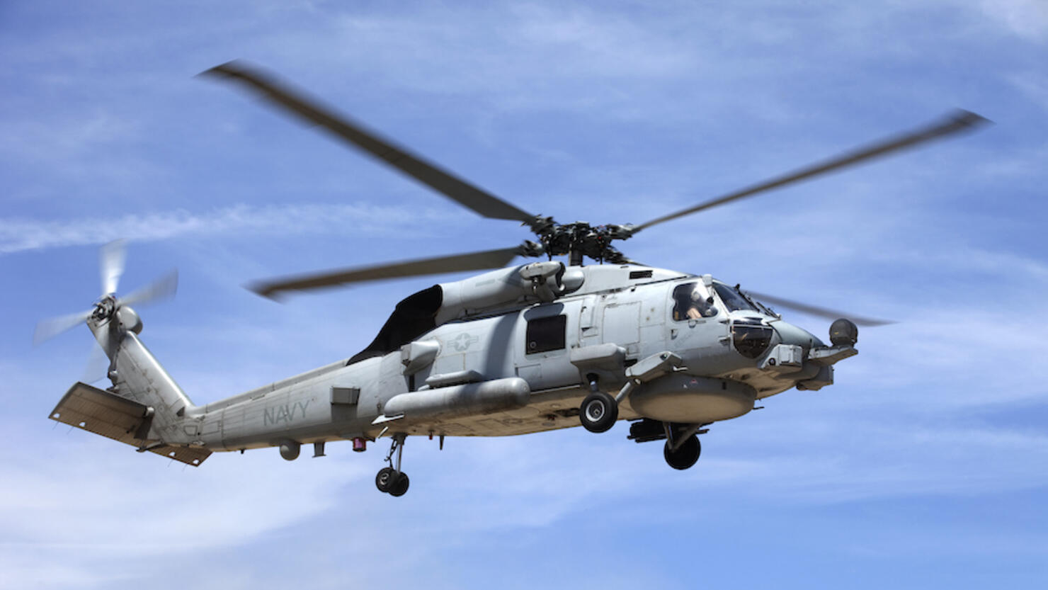 Looking up at a Seahawk helicopter flying in blue sky