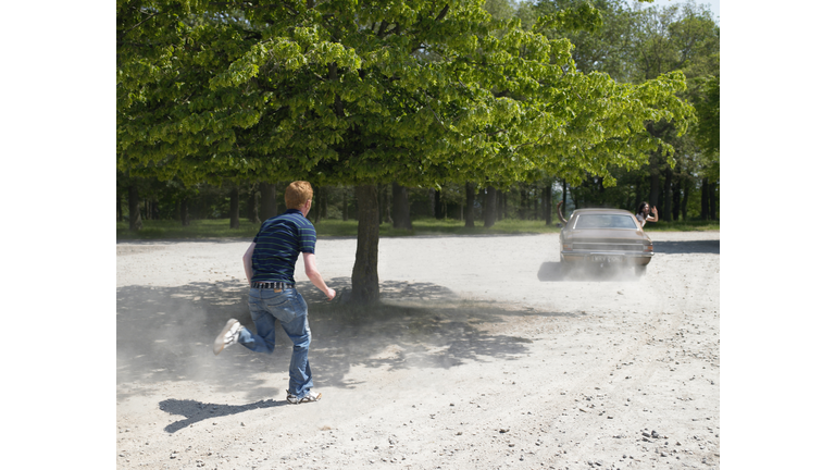 Young man chasing car