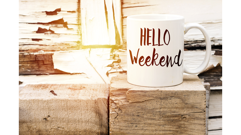 text HELLO weekend on cup of aromatic coffee on wooden cube