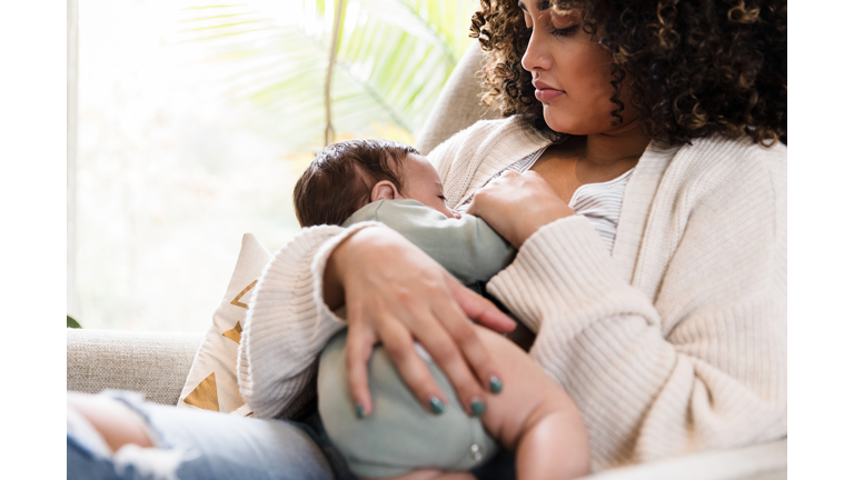 New mom watches as baby breastfeeds