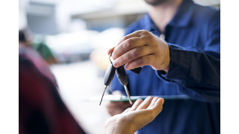 Car repairman giving car keys to customer