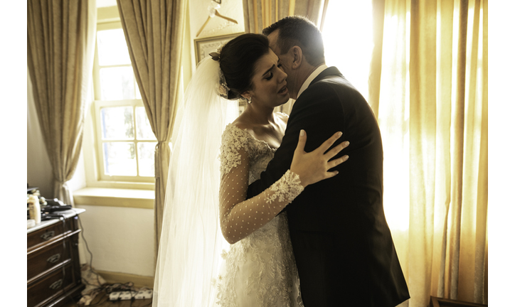 Bride and father embracing before wedding ceremony