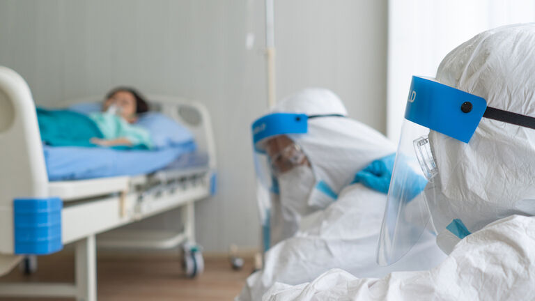 People By Patient Lying On Bed In Hospital