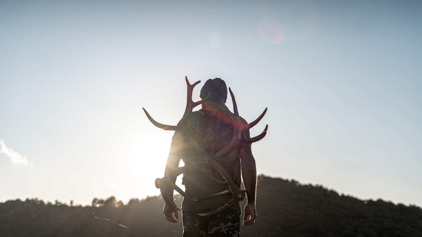 Back light and a man in the mountains with antlers